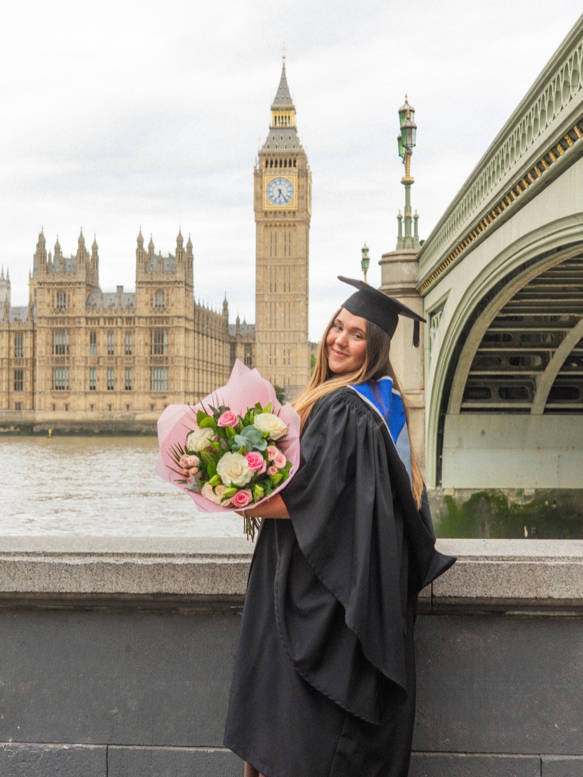 Graduate holding flowers near Westminster
