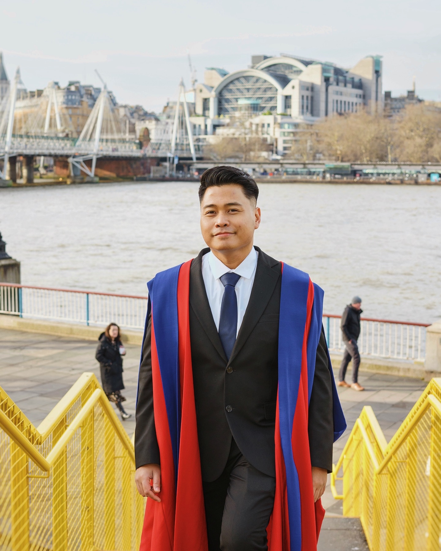 Graduate in academic gown on the Southbank, London
